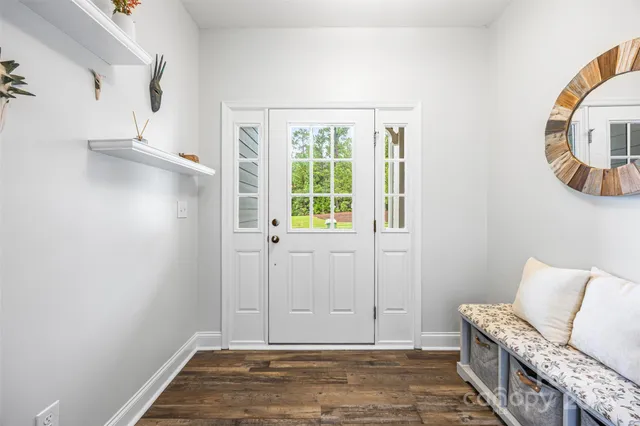 a kitchen with stainless steel appliances granite countertop a dining table chairs refrigerator and microwave