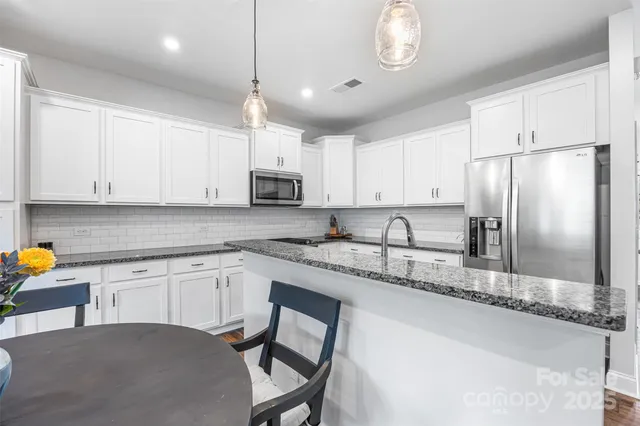 a kitchen with granite countertop a sink stainless steel appliances and counter space