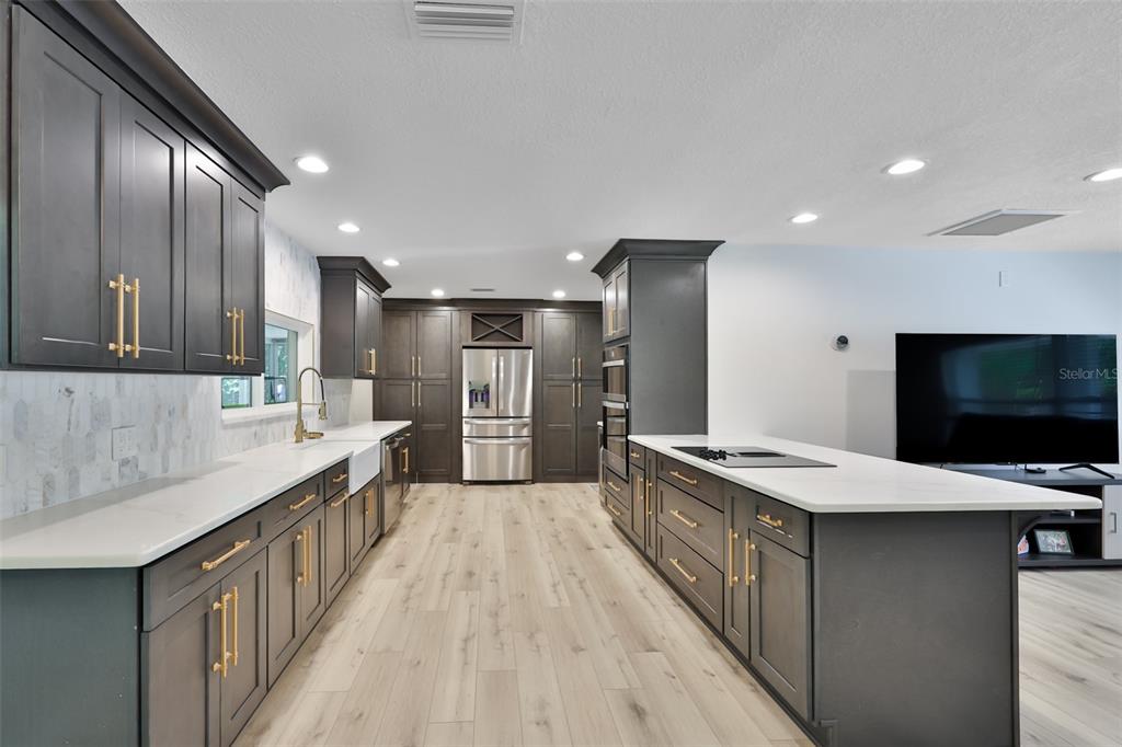 1578 Indian Bay Road Spring Hill, FL 34607 - Photo 16 of 51 a large kitchen with a large counter top stainless steel appliances and cabinets