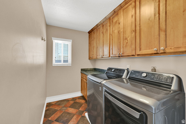 4792 Glasmann Way South Ogden, UT 84403 - Photo 47 of 70 Utility area featuring abundant wood cabinetry, a dark countertop, and tiled flooring