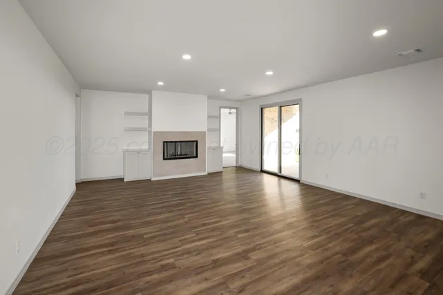 a view of empty room with wooden floor and fireplace