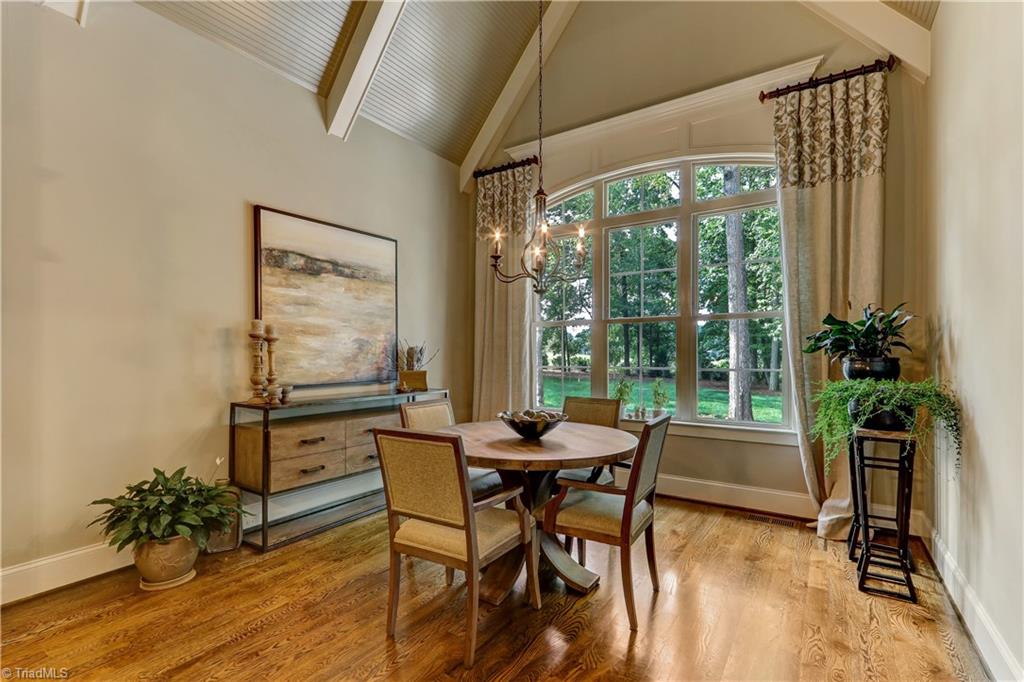 6865 Matzinger Court Oak Ridge, NC 27310 - Photo 10 of 28 The Breakfast Room may turn into your favorite spot - vaulted ceiling with beams and bead board detail looking into the beautiful back yard through a wall of windows. Hardwood flooring and extensive use of moldings continue as throughout the public living spaces.