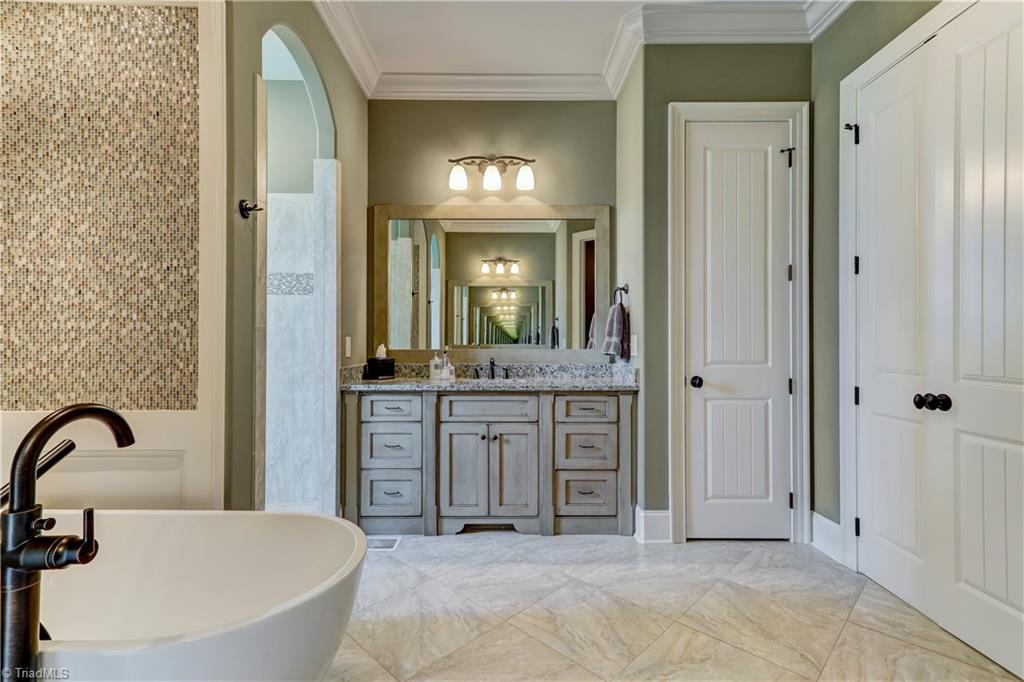 6865 Matzinger Court Oak Ridge, NC 27310 - Photo 14 of 28 This view of the Master Bath shows one of the two matching vanities - plenty of drawer and cabinet storage. Door seen on right side of vanity is a linen closet.