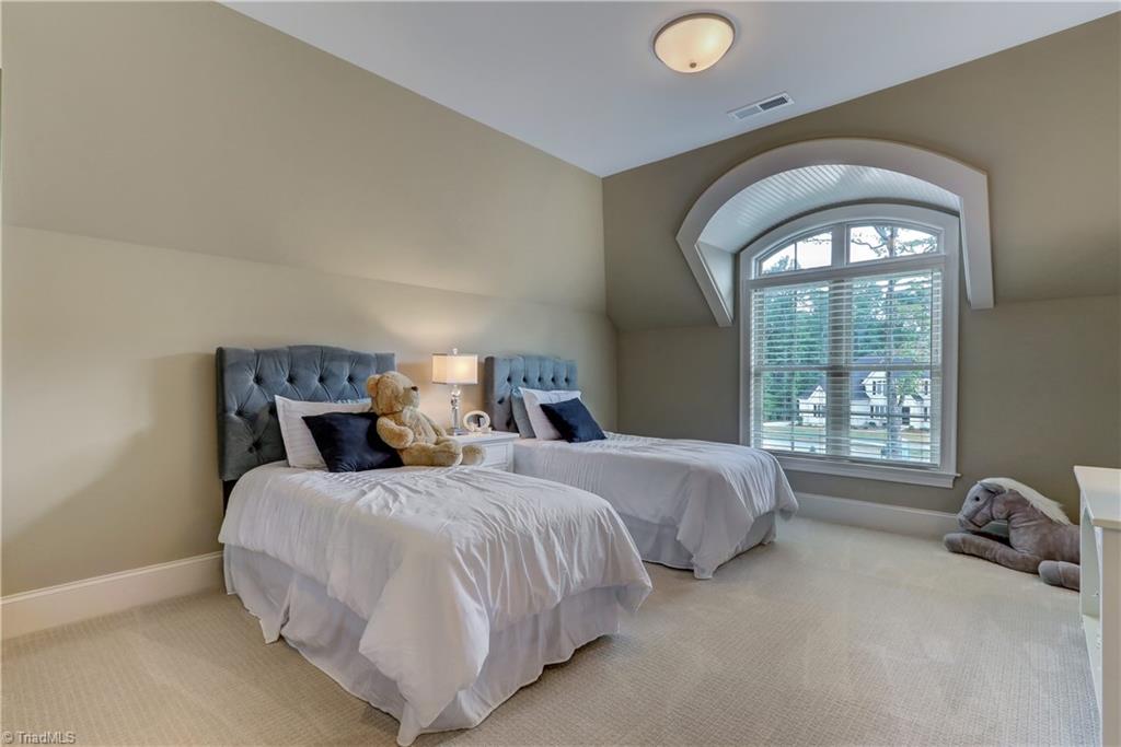 6865 Matzinger Court Oak Ridge, NC 27310 - Photo 20 of 28 Bedroom 3 has wall to wall carpeting, base molding, ceiling light, and architectural window details. Windows have wood blinds. Shared Jack and Jill bath - each bedroom having its own sink/vanity.