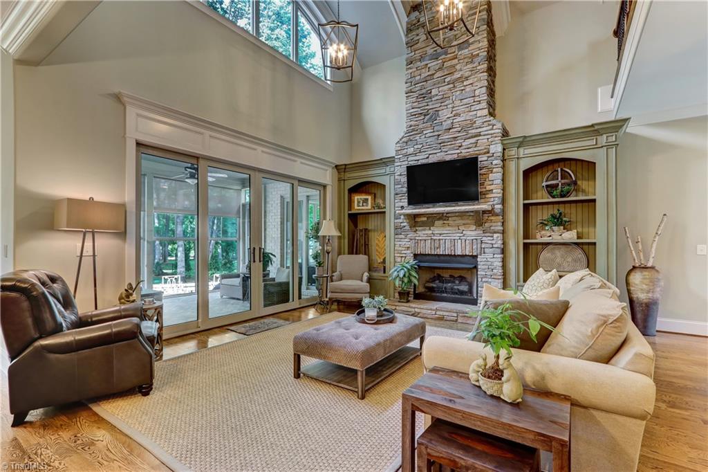 6865 Matzinger Court Oak Ridge, NC 27310 - Photo 4 of 28 Another view of the Great Room showing the gas log fireplace with stone hearth, mantel, and surround. Custom built in shelving with bead board details flank the fireplace.