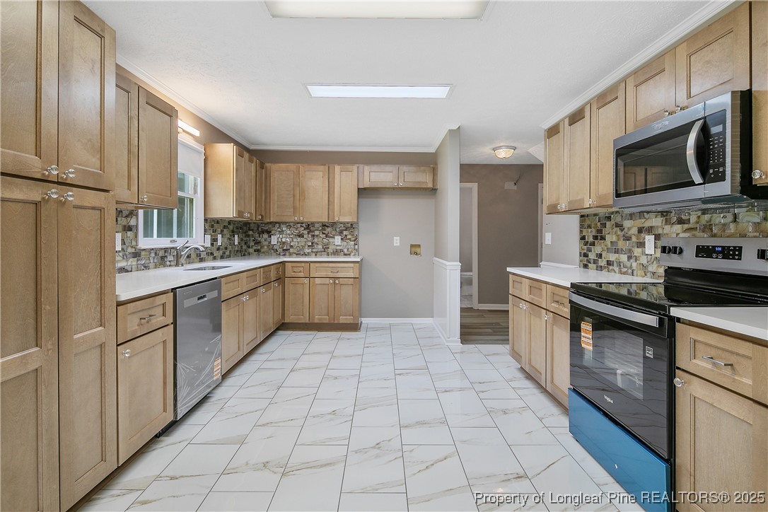 6062 Midus Street Hope Mills, NC 28348 - Photo 12 of 49 a kitchen with stainless steel appliances a sink cabinets and microwave