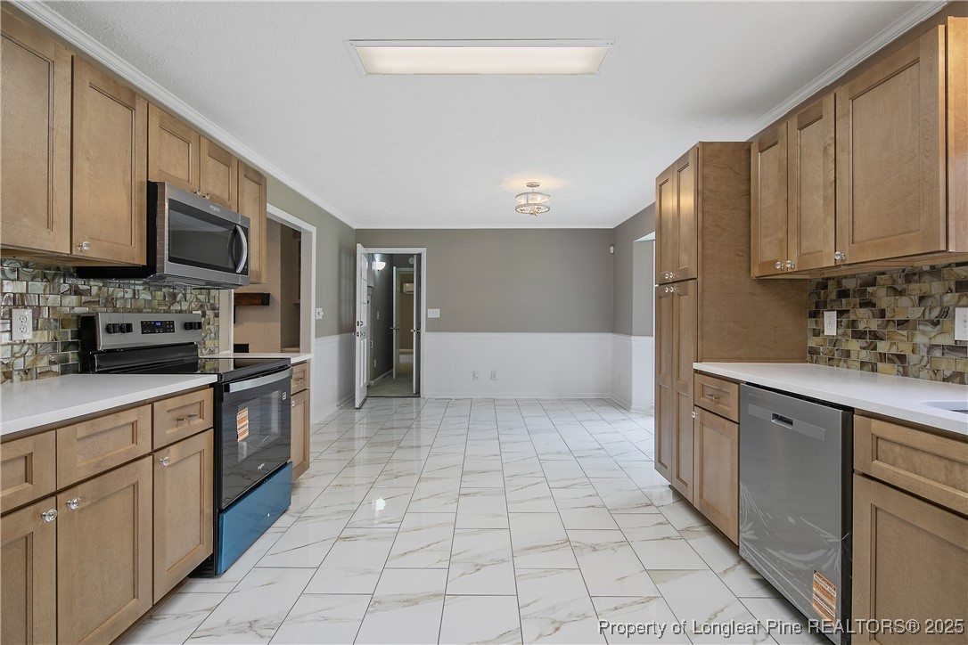 6062 Midus Street Hope Mills, NC 28348 - Photo 15 of 49 a large kitchen with stainless steel appliances granite countertop a stove a sink and a microwave