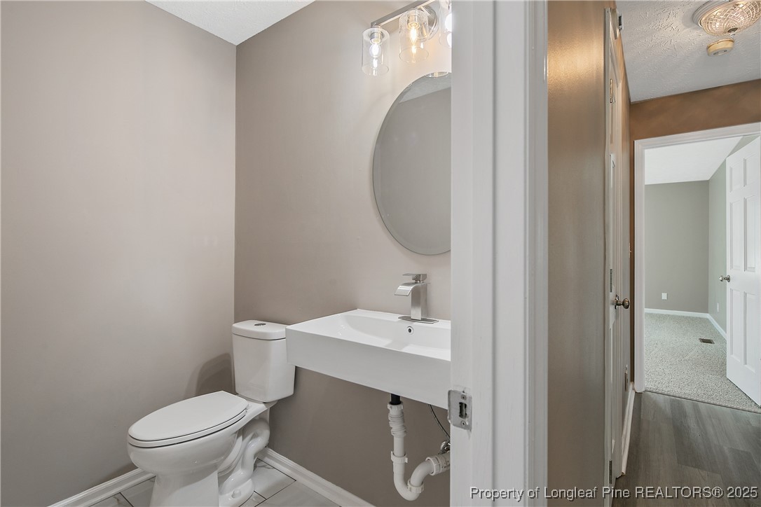 6062 Midus Street Hope Mills, NC 28348 - Photo 23 of 49 a bathroom with a toilet sink and mirror