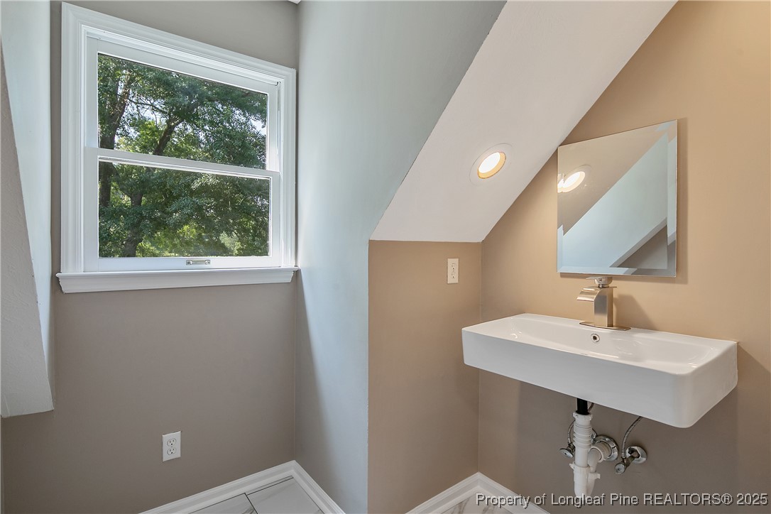 6062 Midus Street Hope Mills, NC 28348 - Photo 34 of 49 a bathroom with a sink a mirror and a window