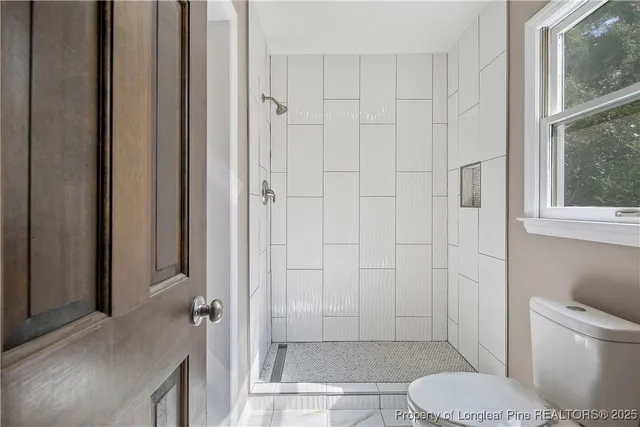 a bathroom with a toilet and a shower