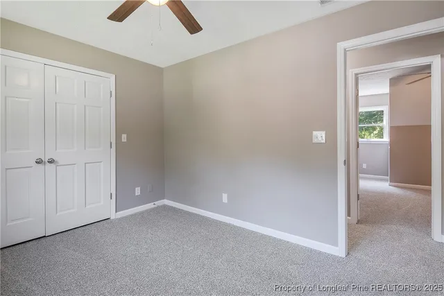 an empty room with closet and windows