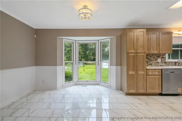a view of an empty room with window and cabinet