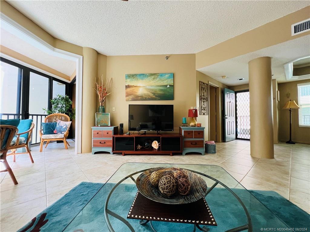 221 Northeast Plantation Road, Unit 215 Stuart, FL 34996 - Photo 16 of 83 a living room with furniture and a flat screen tv