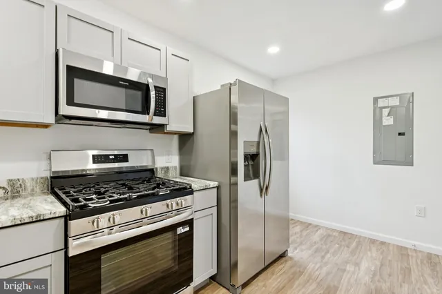 a kitchen with stainless steel appliances granite countertop a stove microwave and refrigerator