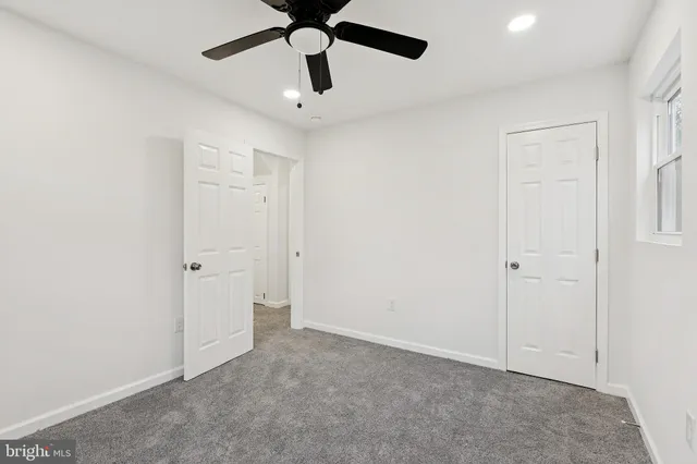 an empty room with a ceiling fan and a window