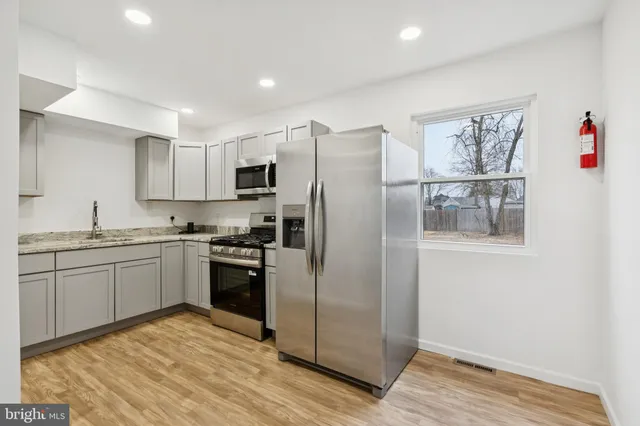 a kitchen with stainless steel appliances granite countertop a refrigerator and a stove top oven