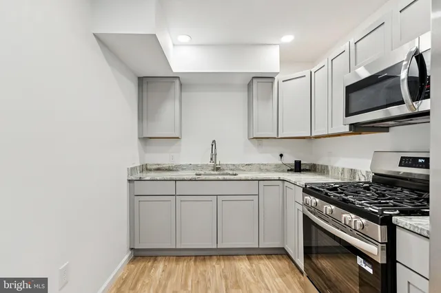 a kitchen with stainless steel appliances granite countertop a stove and a microwave