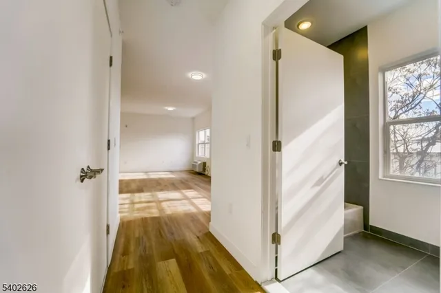 a view of a hallway with wooden floor and staircase