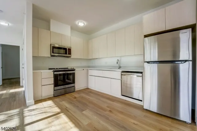 a kitchen with white cabinets and stainless steel appliances