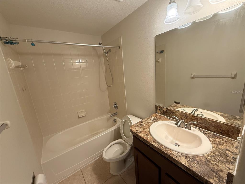 9854 Trumpet Vine Loop, Unit 9854 Trinity, FL 34655 - Photo 13 of 19 a bathroom with a granite countertop sink toilet and shower