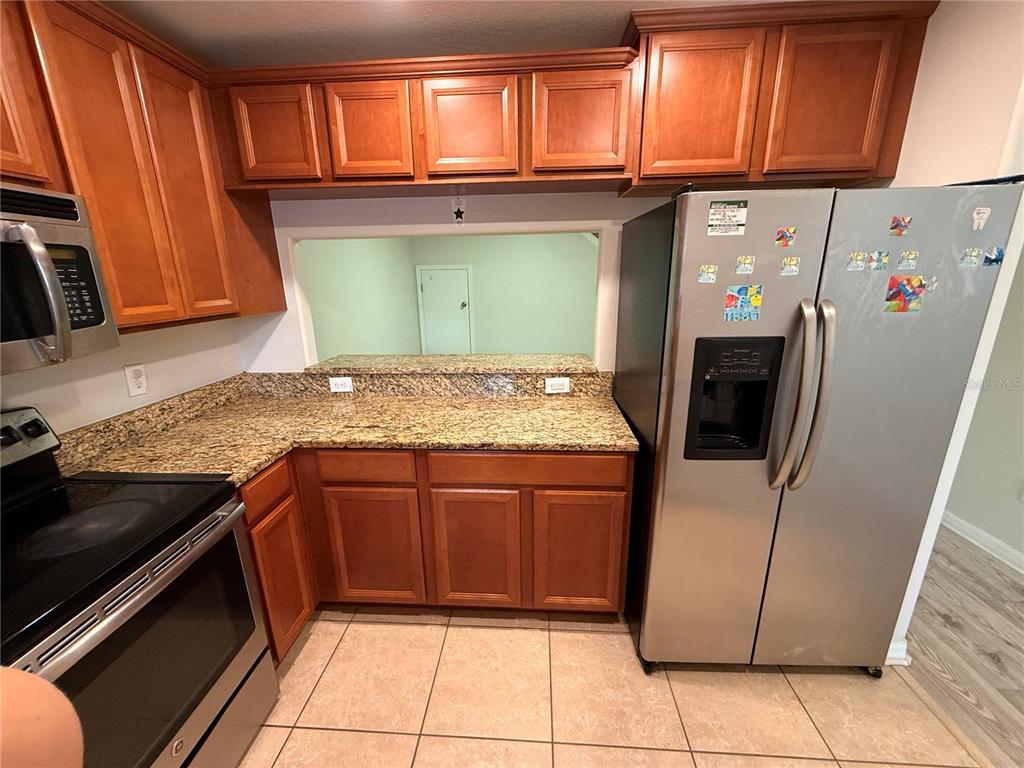 9854 Trumpet Vine Loop, Unit 9854 Trinity, FL 34655 - Photo 4 of 19 a kitchen with stainless steel appliances granite countertop a refrigerator and a sink