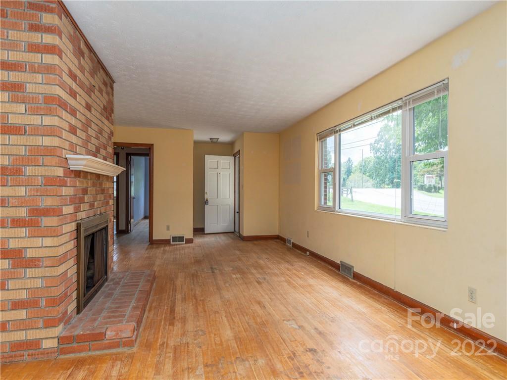764 North Canton Road Canton, NC 28716 - Photo 3 of 16 a view of empty room with fireplace and wooden floor