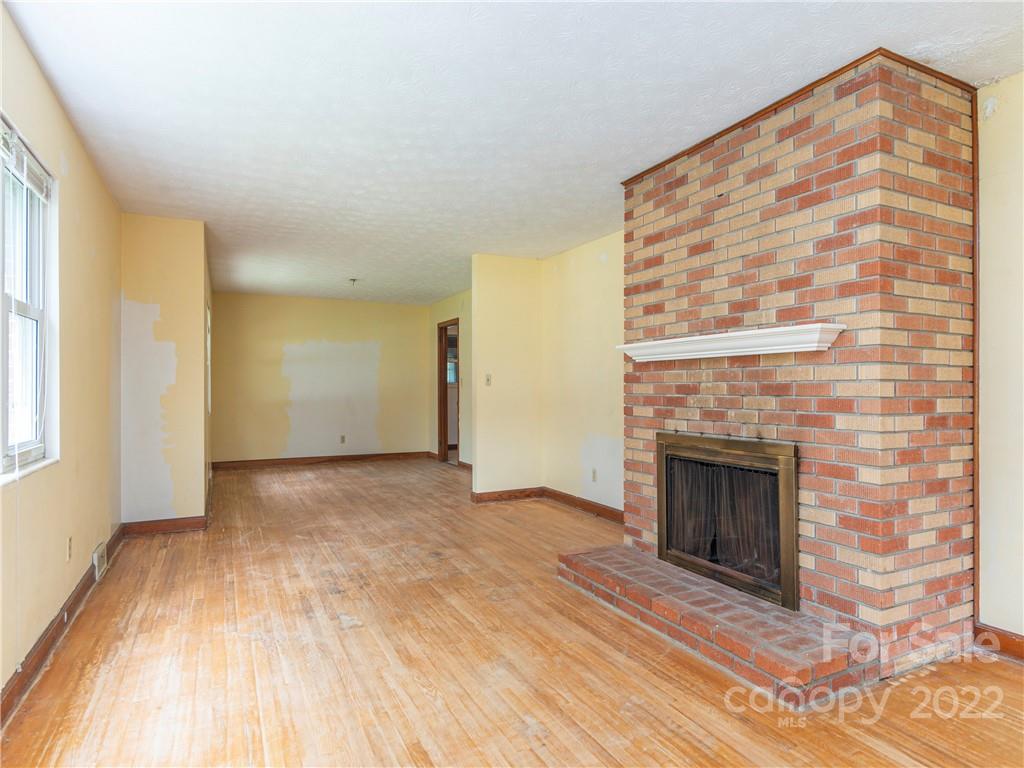 764 North Canton Road Canton, NC 28716 - Photo 4 of 16 a view of empty room with wooden floor and fireplace