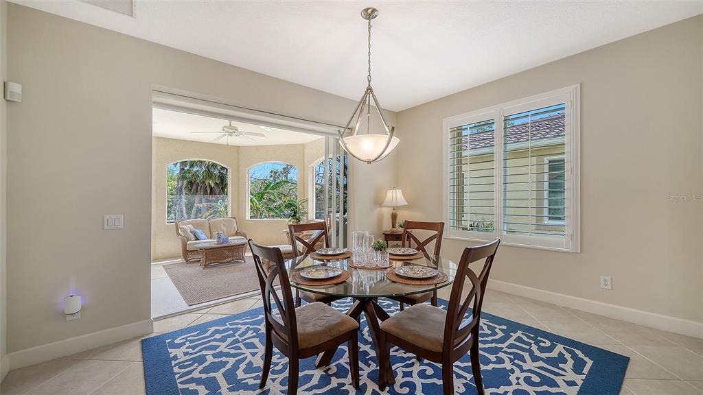 1116 Beachcomber Court, Unit 3 Osprey, FL 34229 - Photo 12 of 65 a dining room with furniture a chandelier and wooden floor