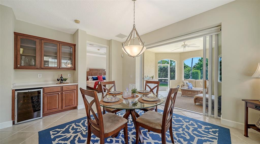 1116 Beachcomber Court, Unit 3 Osprey, FL 34229 - Photo 13 of 65 a dining room with wooden floor a chandelier a wooden table and chairs