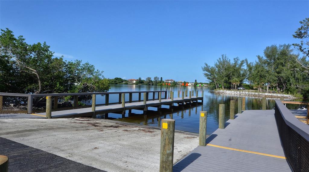 1116 Beachcomber Court, Unit 3 Osprey, FL 34229 - Photo 62 of 65 a view of a lake with boats and wooden bridge