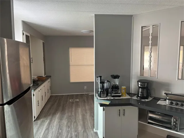 a kitchen with granite countertop a sink stove and refrigerator