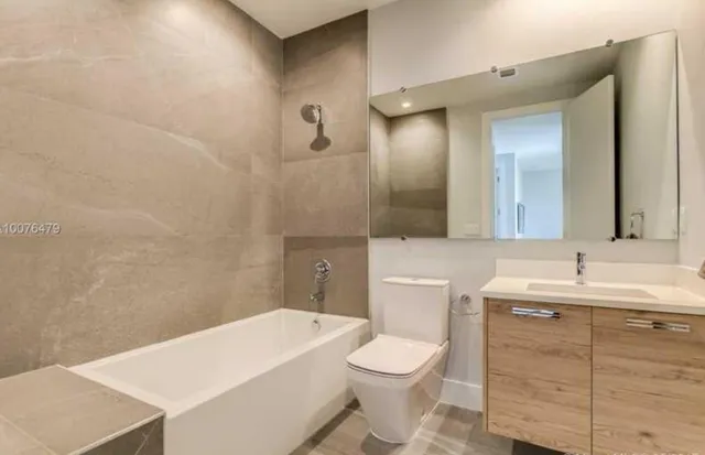 a bathroom with a toilet a sink a mirror and vanity