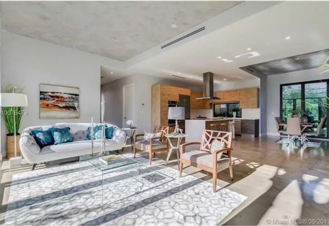 a living room with furniture and kitchen view