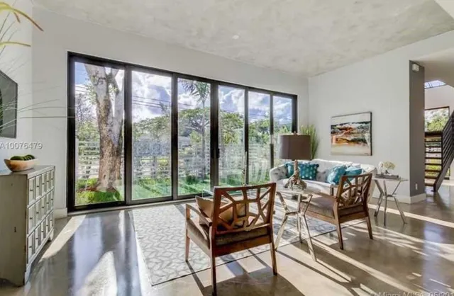 a living room with furniture and a floor to ceiling window