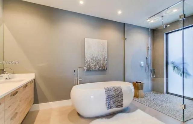 a bathroom with a tub sink and mirror