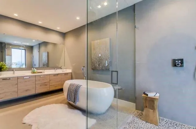 a bathroom with a granite countertop sink mirror and bathtub