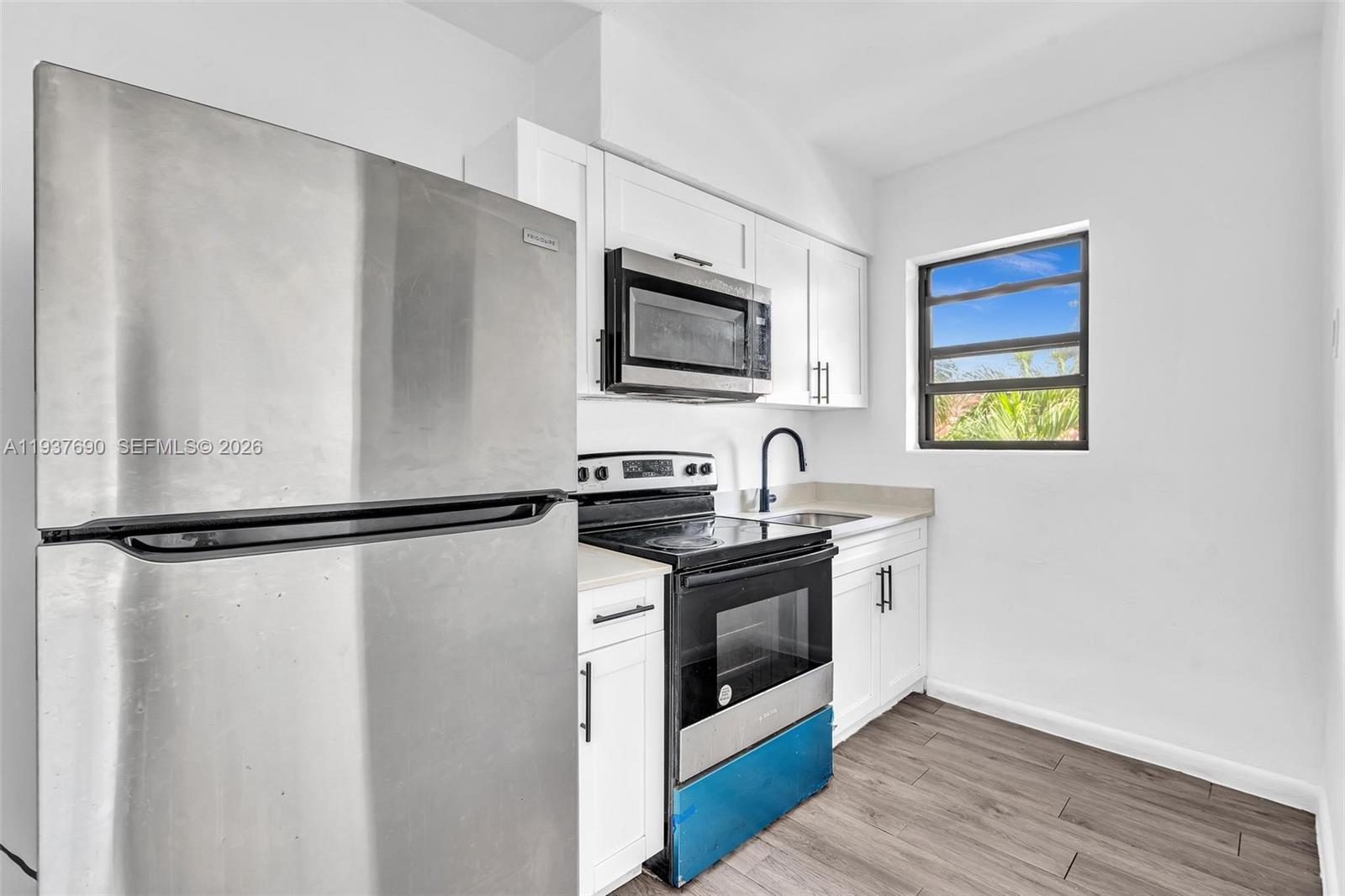 1027 Southwest 3rd Street, Unit 5 Miami, FL 33130 - Photo 2 of 6 a kitchen with stainless steel appliances a refrigerator sink and stove