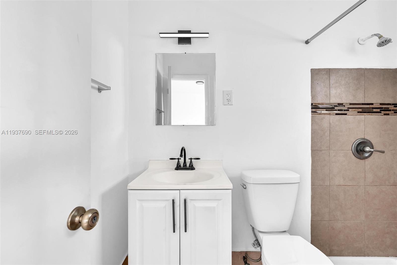 1027 Southwest 3rd Street, Unit 5 Miami, FL 33130 - Photo 4 of 6 a bathroom with a toilet sink and mirror