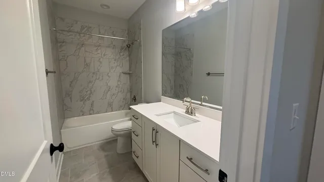 a view of an empty room with closet and a bathroom