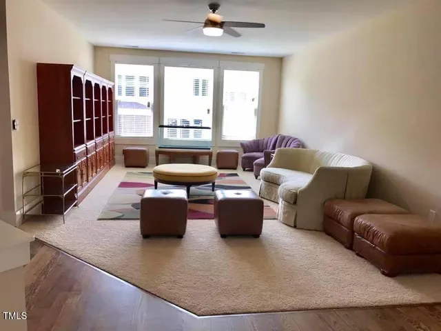 a living room with furniture a flat screen tv and a window