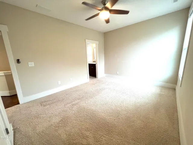 en empty room with windows and fan