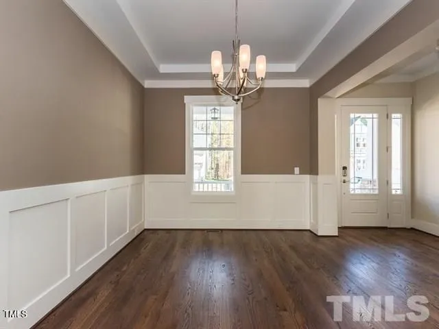 a view of a room with wooden floors and chandelier