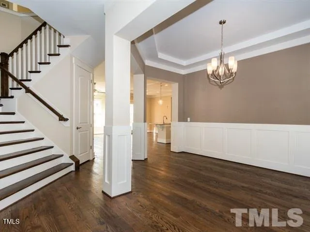 a view of a livingroom with wooden floor and stairs