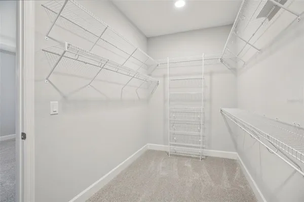 a view of walk in closet with empty racks