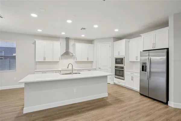 a kitchen with kitchen island a sink stainless steel appliances and cabinets