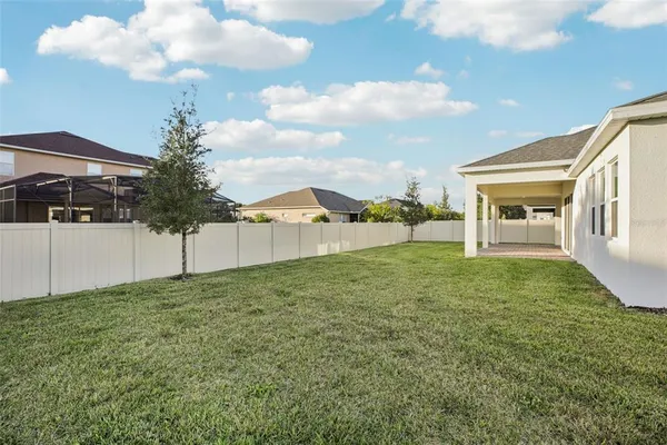 a view of house with swimming pool and yard