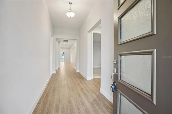 a view of a hallway with wooden floor and staircase