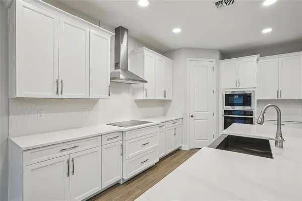 a kitchen with white cabinets and stainless steel appliances