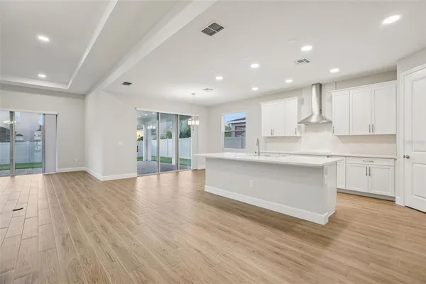 a large kitchen with stainless steel appliances granite countertop a large counter top a sink and a refrigerator