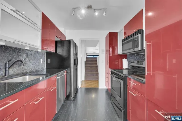 a kitchen with stainless steel appliances granite countertop a sink and a stove